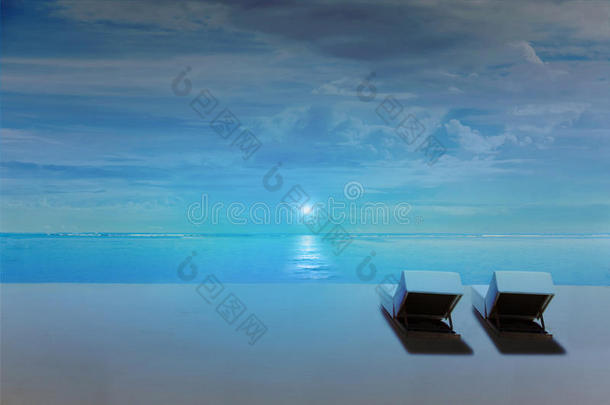 海滩上的椅子在夜晚随着月亮的升起，深蓝色的环境