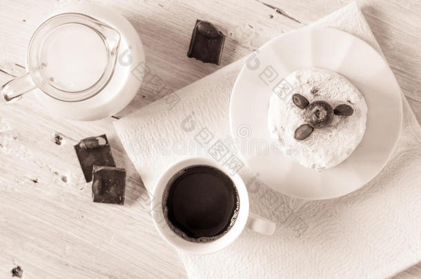 一杯咖啡，配上一壶牛奶蛋糕和巧克力，<strong>放在</strong>白色的<strong>桌面</strong>上