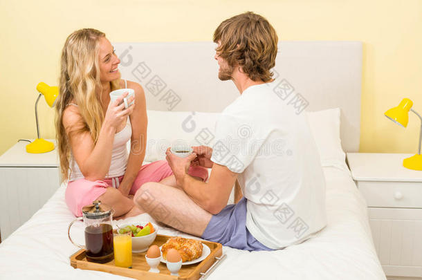 一对可爱的夫妇坐在床上吃早餐