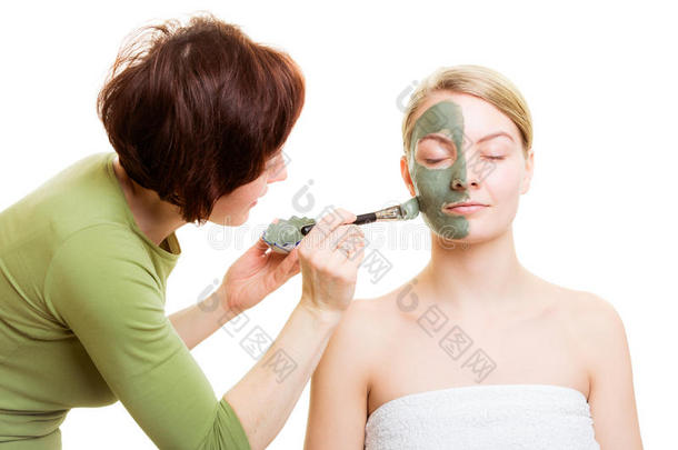 化<strong>妆</strong>师在女人脸上涂上粘土<strong>面膜</strong>。