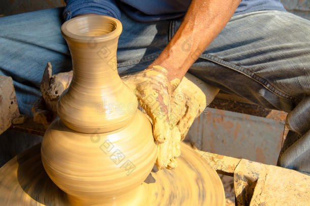 手在陶轮上制作陶罐，选择焦点，特写。