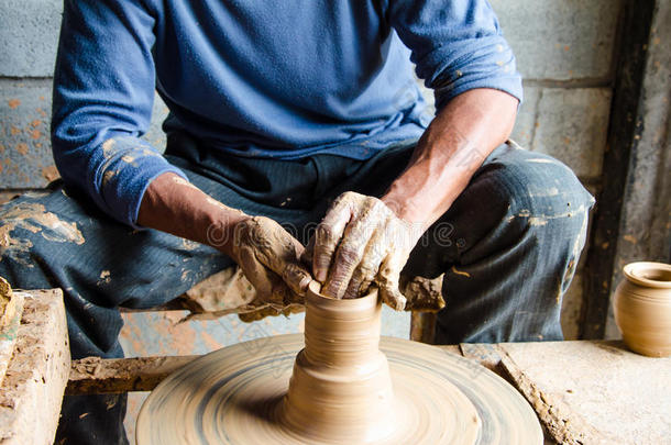 手在陶轮上制作陶罐，选择焦点，特写。
