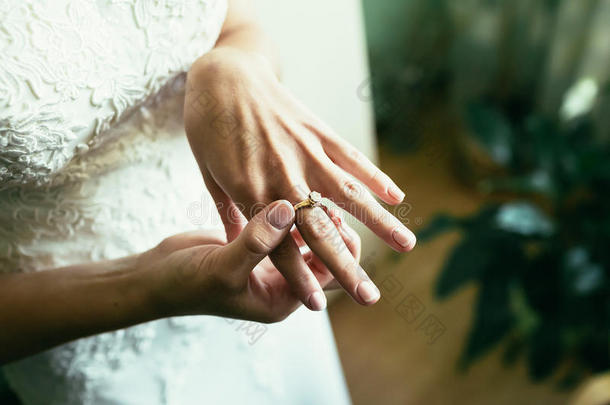 金色优雅的结<strong>婚戒</strong>指与<strong>钻石</strong>在新娘手指在婚礼当天特写