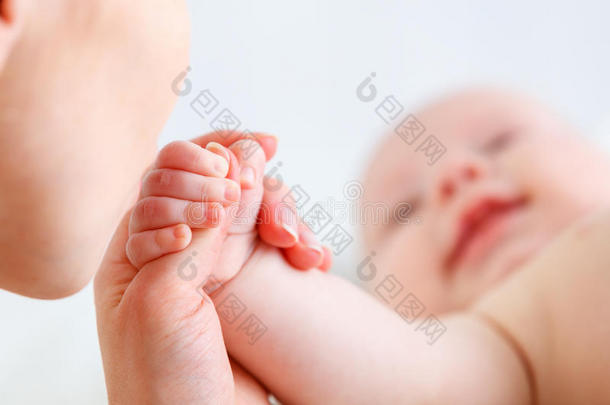 父母爱的概念。 婴儿的手握着母亲的手指