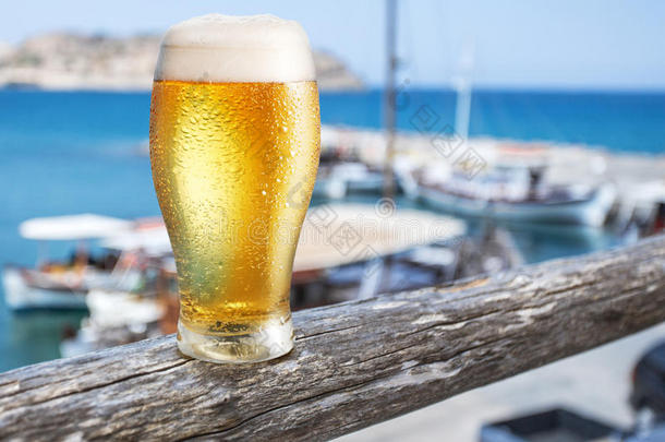 海边酒吧柜台上的一杯淡啤酒。 医生里的船