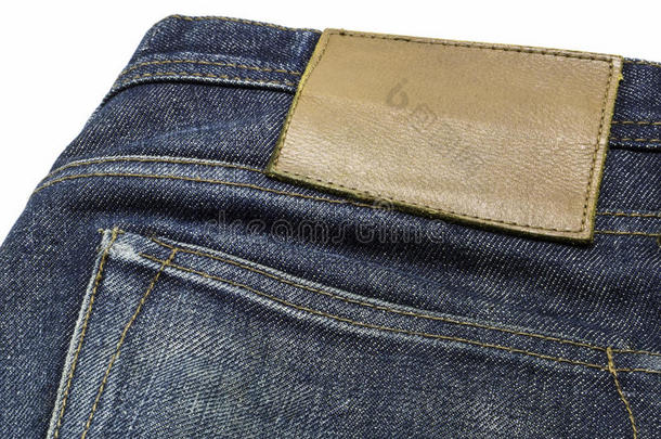 缝在蓝色牛仔裤上的空白皮革牛仔裤标签。
