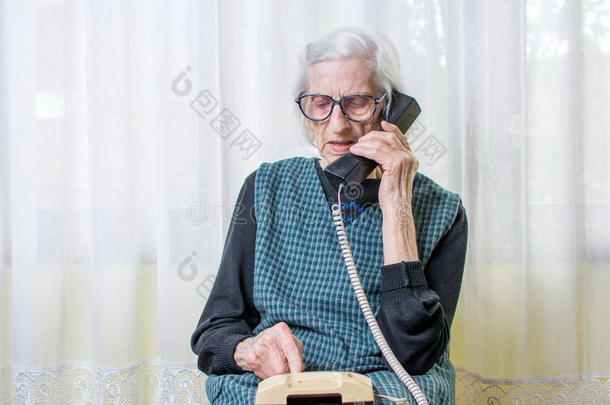 老年妇女在室内使用电话