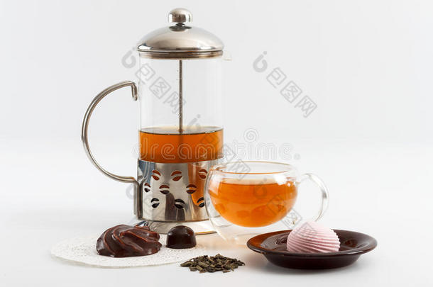 玻璃茶壶与双面墙玻璃杯充满绿茶与糖果和饼干