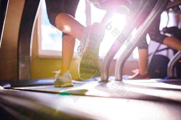 在跑步机上跑步的女人腿的细节，健身房