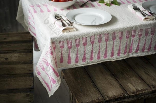 餐具套装在桌子上，铺着叉子图案的桌子