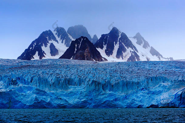 深冬山与雪，蓝色冰川冰与海洋在前景，斯瓦尔巴，挪威，欧洲