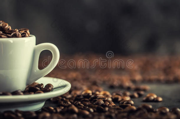 咖啡豆。 装满咖啡豆的咖啡杯。 色调的图像