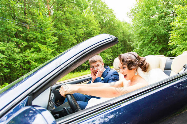 美丽的年轻夫妇新娘和新郎在<strong>敞篷</strong>车里摆姿势