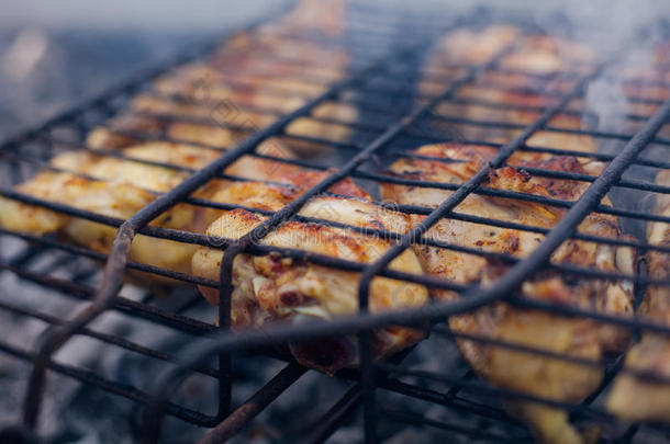烤鸡腿在烤架上，用煤和烟混合