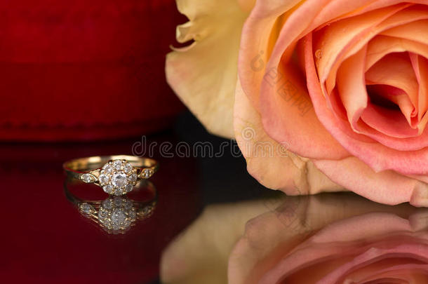 黄金订婚，玫瑰和镜子背景上的一个盒子。