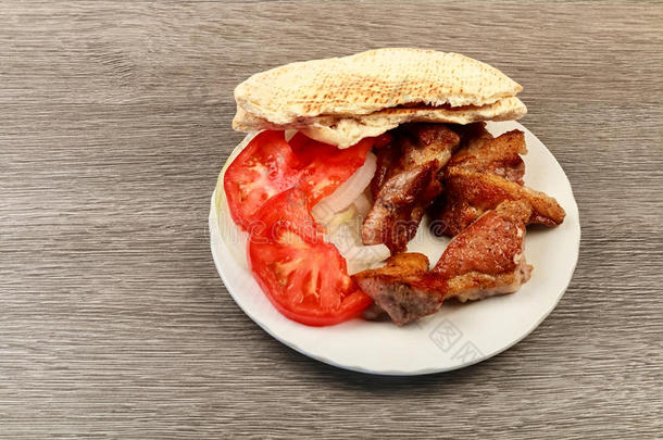 希腊苏夫拉基与皮塔面包和蔬菜特写在桌子上。 猪肉桌子