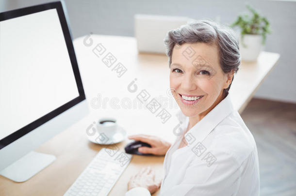 坐在电脑桌前的快乐女商人