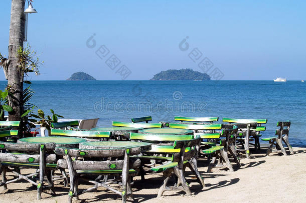 绿色混凝土水泥椅子的形状和纹理，如木材，供游客在海滩<strong>度假餐厅</strong>和椰子树上的灯