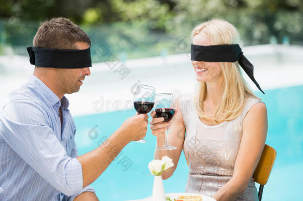 蒙着眼睛的夫妇一边品尝红酒
