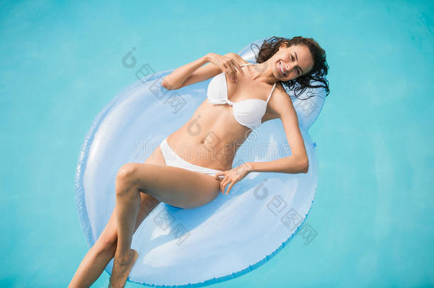 美丽的年轻女人在游泳圈上放松