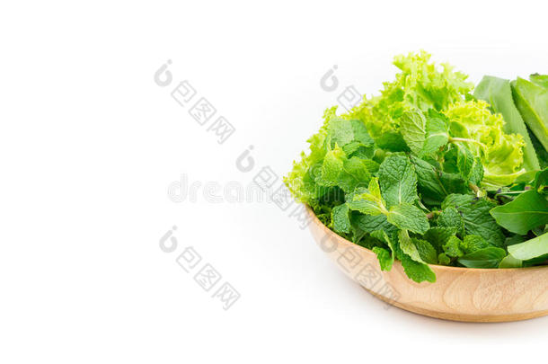 白色背景的木制盘子里的绿色蔬菜