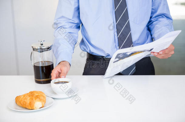 商人<strong>一桌</strong>拿着咖啡杯和报纸