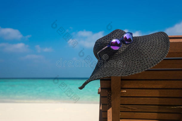 白色沙滩上带帽子的沙滩椅子