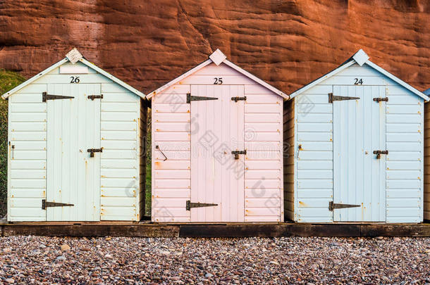 海滩小屋排在柔和的颜色，红色的岩石背景