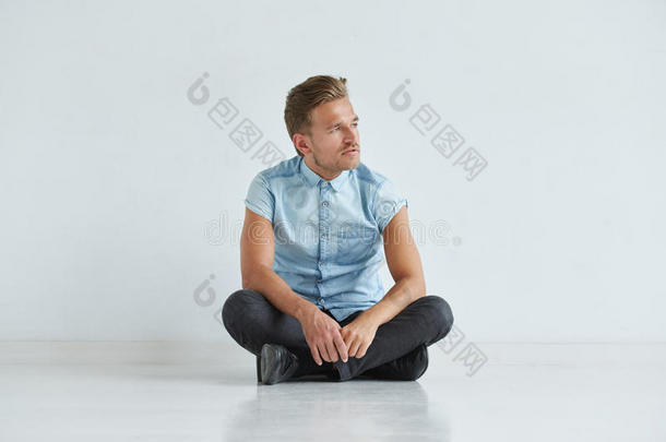 穿着<strong>短袖衬衫</strong>的残暴男子坐在莲花的姿势下，