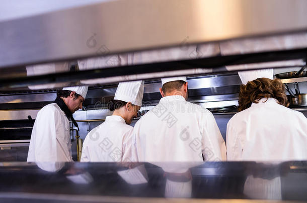 一群穿着白色制服的厨师忙着准备食物