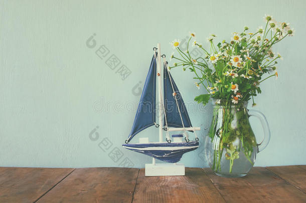 木制桌子上木船旁边的新鲜雏菊花。 <strong>陈年</strong>过滤