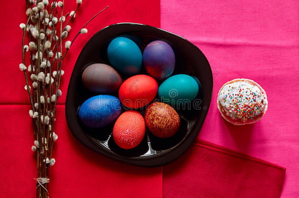 节日复活节餐桌上有五颜六色的鸡蛋、蛋糕和柳树枝