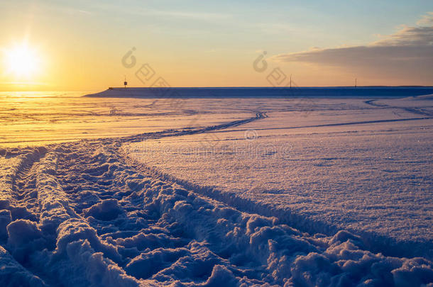 日落时穿过乡村滑雪道向码头走去。 美丽的冬天场景。