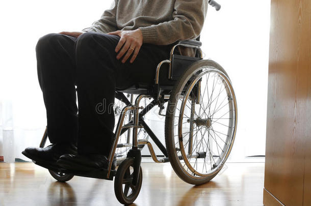 在房间里<strong>坐轮椅的</strong>残疾<strong>老人</strong>