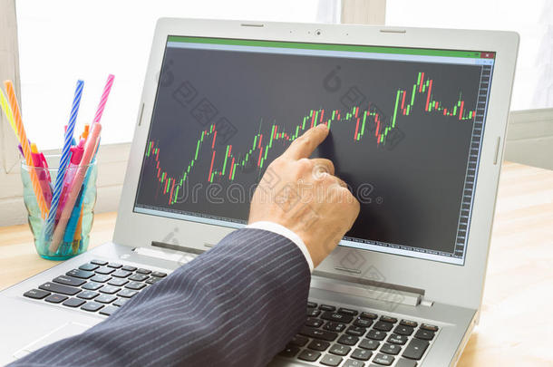 商人用右手手指点分析外汇图或股票图