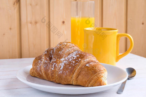 白色木桌上的牛角面包、咖啡和橙汁