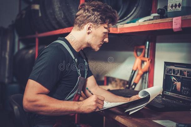 <strong>汽车修理</strong>工在他的工作场所准备<strong>汽车修理</strong>服务的清单。
