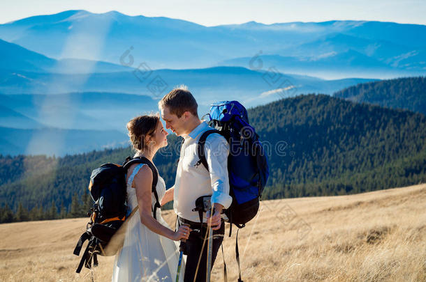 美丽的旅游婚礼夫妇拥抱在山顶上。 在阿尔卑斯山度蜜月
