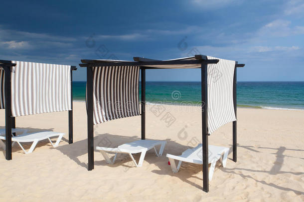 风暴来临前，阿尔加<strong>维</strong>，塔<strong>维</strong>拉岛上空旷的海滩上挂着不同的阳伞和日光浴。葡萄牙
