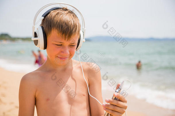 男孩在海滩夏<strong>日</strong>使用智能<strong>手机</strong>