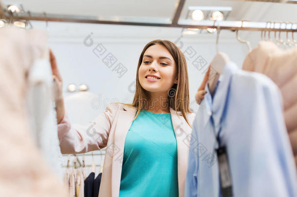 在商场挑选衣服的快乐年轻女人