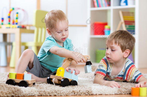孩子们在家里或托儿所玩木车。 学龄前和幼儿园儿童的教育玩具。