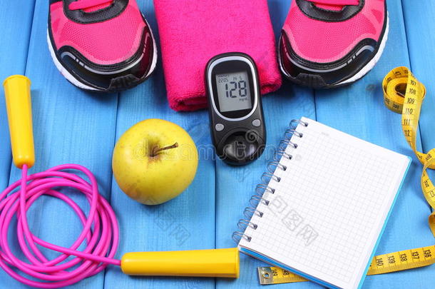 血糖仪，运动鞋，新鲜苹果和配件健身在蓝板，复制空间的文字