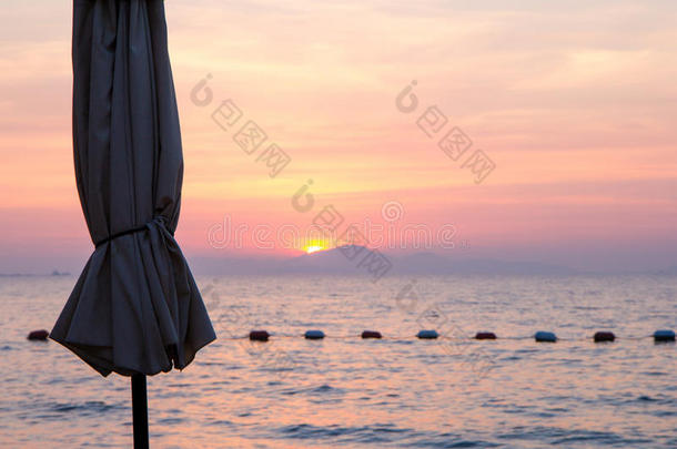 沙滩伞日落在WongAmat海滩芭堤雅