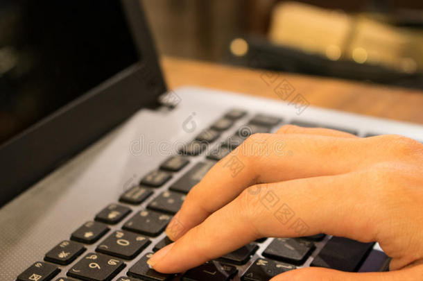 在<strong>咖啡店</strong>用笔记本电脑工作的亚洲女学生的手