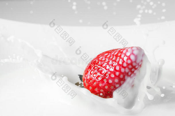 甜点：草莓掉在牛奶里，溅着水花。 红色和白色