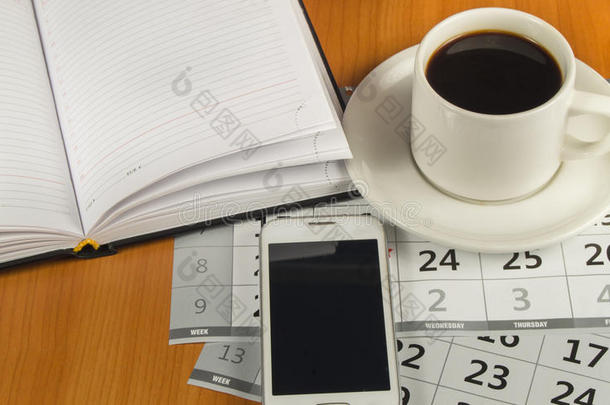 桌面上的咖啡、手机、日记和日历。 文本的空间