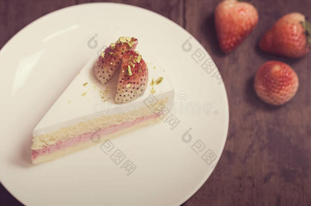 关闭草莓奶油蛋糕在白色的木材背景，复古色调