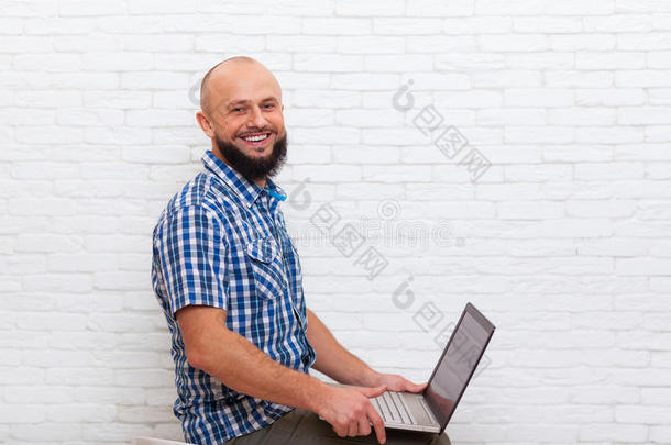 休闲胡须的商务人士坐着笔记本电脑在线交流