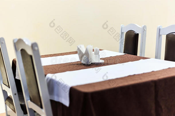 餐厅桌子的一般视图，桌子上覆盖着桌布和餐巾